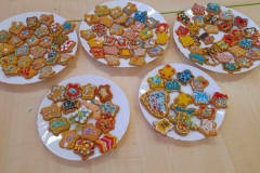 Kolorowe, udekorowane ciasteczka leżą na trzech talerzach.