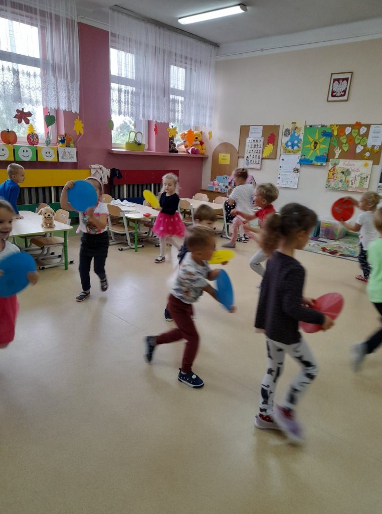 Dzieci biegają po sali udając samochody. Kółka służą im za kierownice.